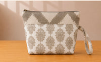 Back view of NO.011 Studio Pouch – Stone Arcade with neutral stone patterned fabric, zipper closure, and matching wrist strap.