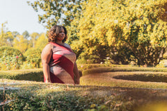 Woman standing in a garden with trees and shrubs in the background