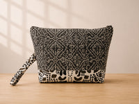 Back view of NO.001 Studio Pouch – Paris Atelier with black geometric textile, ivory dot motif base, and matching wrist strap.