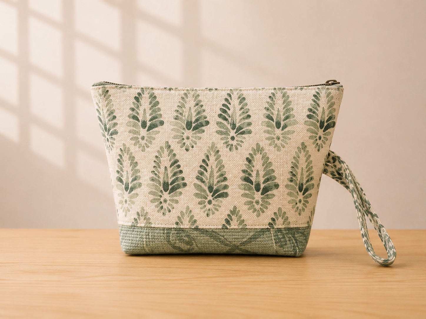 Back view of NO.003 Studio Pouch – Sage Lattice with tonal sage patterned fabric, zipper closure, and matching wrist strap.