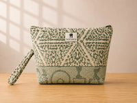 Front view of NO.003 Studio Pouch – Sage Lattice with sage geometric textile, tonal base panel, exterior Toni & Tucker label, and wrist strap.