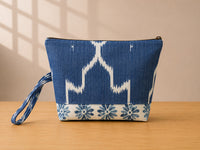 Back view of NO.005 Studio Pouch – Indigo Ikat with blue patterned textile, zipper closure, and matching wrist strap.