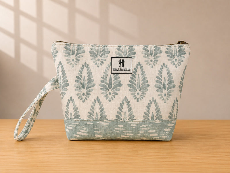 Front view of NO.006 Studio Pouch – Mist Fern with soft blue gray textile, label, zipper closure, and wrist strap.