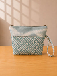 Back view of NO.007 Studio Pouch – Blue Courtyard with blue and cream patterned textile, zipper closure, and matching wrist strap.