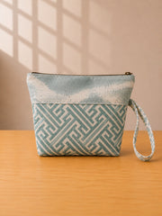 Back view of NO.007 Studio Pouch – Blue Courtyard with blue and cream patterned textile, zipper closure, and matching wrist strap.
