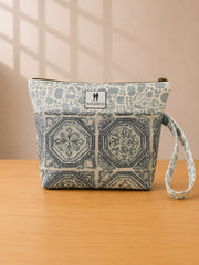 Front view of NO.007 Studio Pouch – Blue Courtyard with blue courtyard-inspired textile, exterior Toni and Tucker label, zipper closure, and wrist strap.