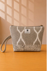 Front view of NO.009 Studio Pouch Sandstone Key with neutral patterned fabric, label, zipper closure, and wrist strap.