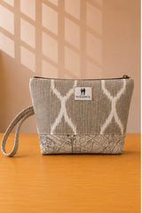 Front view of NO.009 Studio Pouch Sandstone Key with neutral patterned fabric, label, zipper closure, and wrist strap.