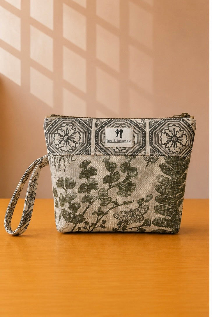 Front view of NO.012 Studio Pouch Botanical Conservatory with botanical and tile patterned fabric, label, zipper closure, and wrist strap.